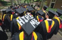 College student wears a cap that reads "Hire Me" on their way to graduation. PHOTO/HACKCOLLEGE